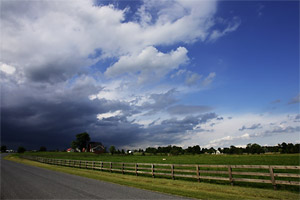 A wide angle shot of view on stormy clouds covering a farm land