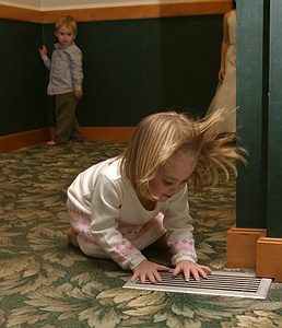 A girl playing with a/c vent